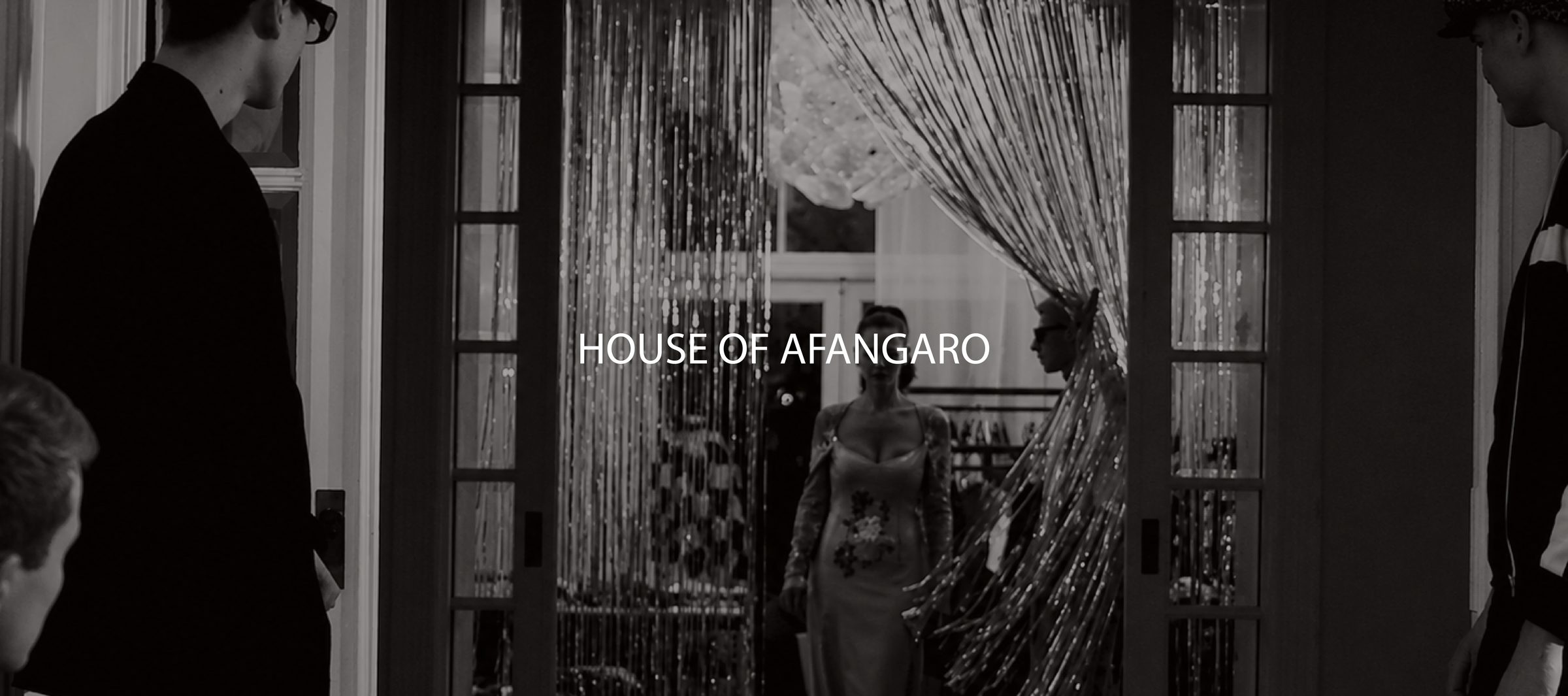House of Afangaro brand film still — guests arriving through a beaded curtain entrance, black and white