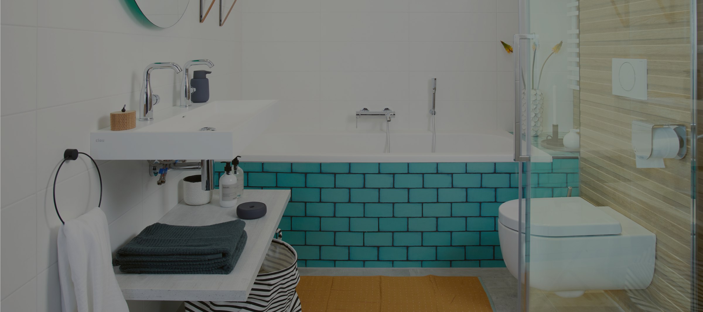Panoramisch overzicht van een badkamer in Debadkamer.nl-stijl, met turquoise tegels en een vrijstaand bad