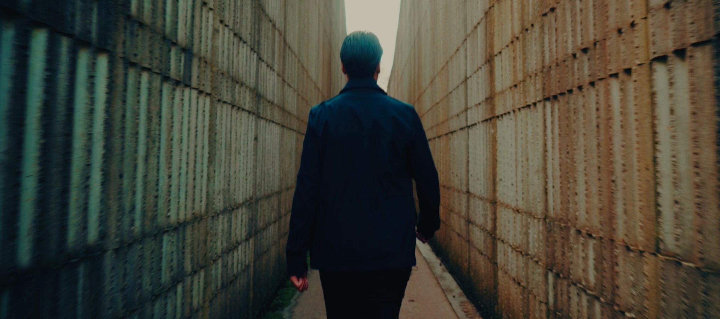 A guest walking through one of the fort's long brick corridors — brand film still